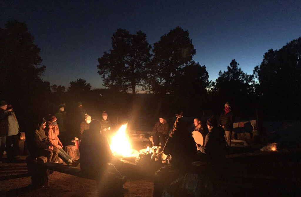 small community at a fire ceremony during winter solstice lead by Dr. Tom Garcia