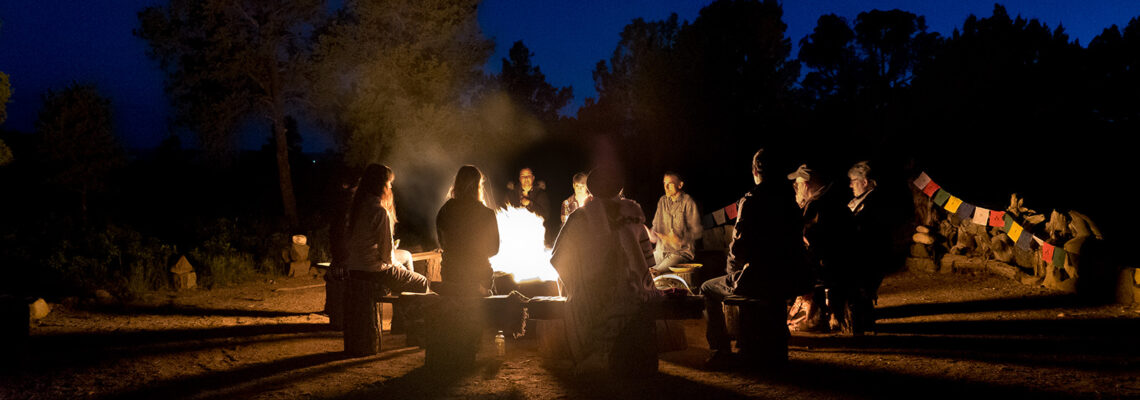 community sitting around a fire ceremony at night